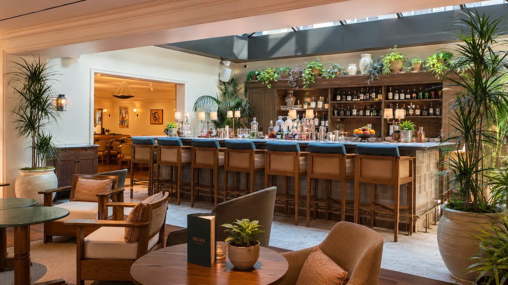 Borneta Barcelona hotel bar with warm wood, plants, and relaxed boutique lounge seating
