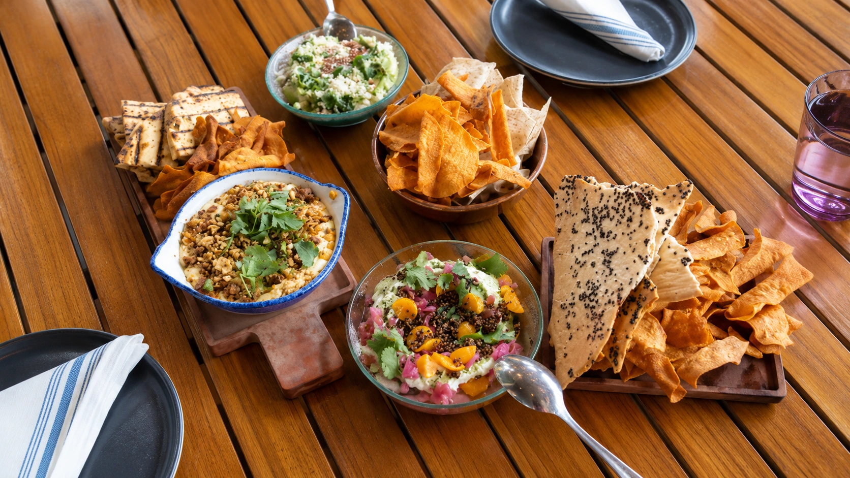 Peruvian shared plates and chips on a wood table at Cabra Chicago