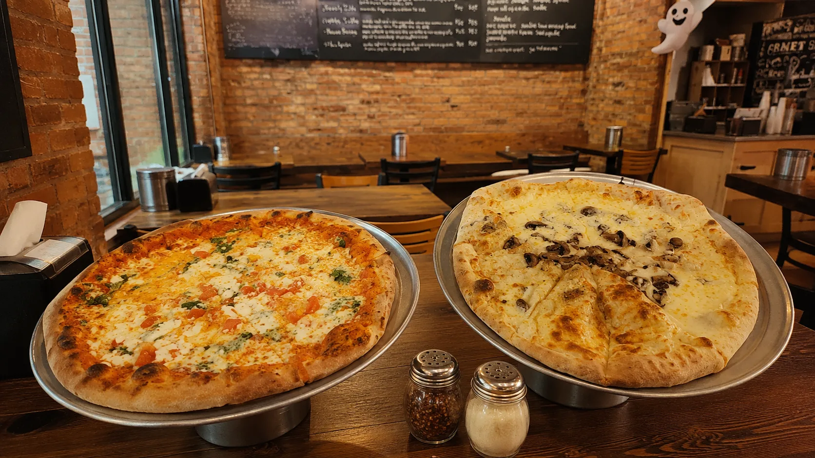 Two thin crust pizzas on trays at Craft Pizza in Chicago