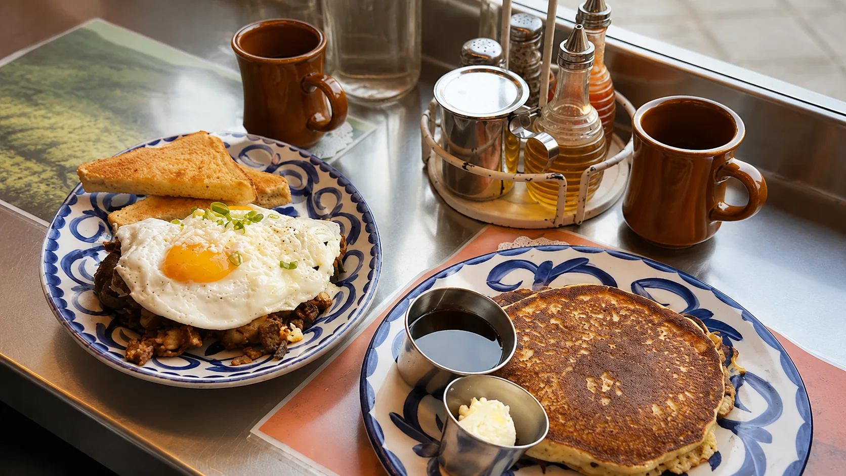 Breakfast plates with pancakes and eggs at Dove’s Luncheonette Chicago