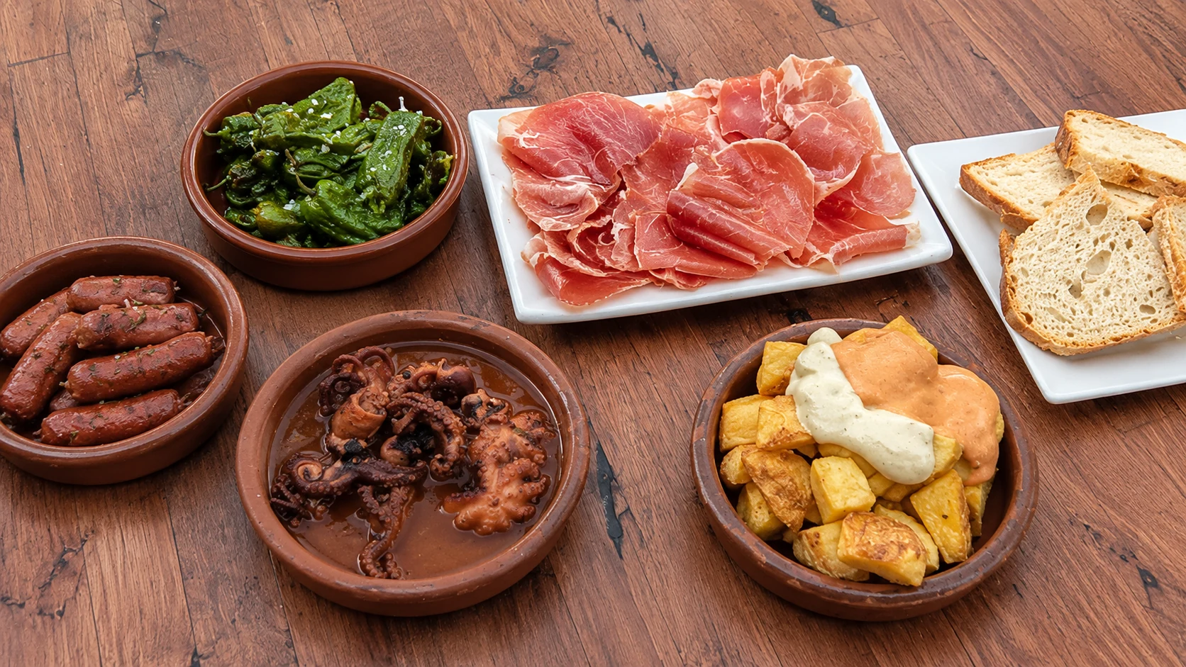 Bar La Plata Barcelona jamón, sausage, fried potatoes, bread, and tapas on a table