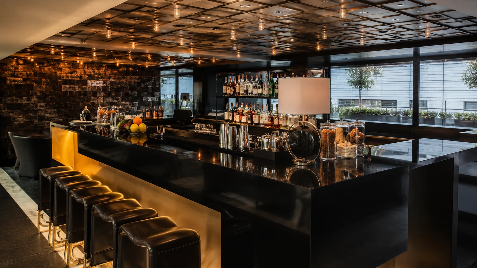 Mandarin Oriental Barcelona hotel bar with black marble counter, warm lighting, and upscale seating