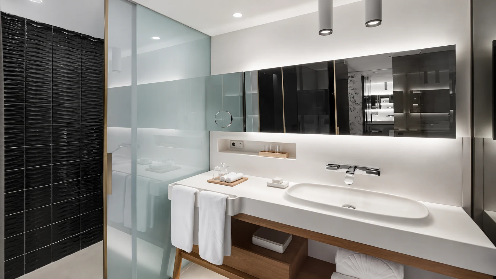 Mandarin Oriental Barcelona modern bathroom with white vanity, glass shower, and black tile wall