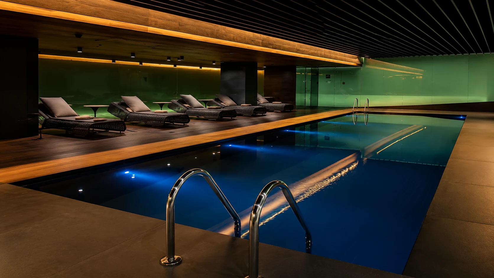 Mandarin Oriental Barcelona indoor spa pool with lounge chairs and warm modern lighting