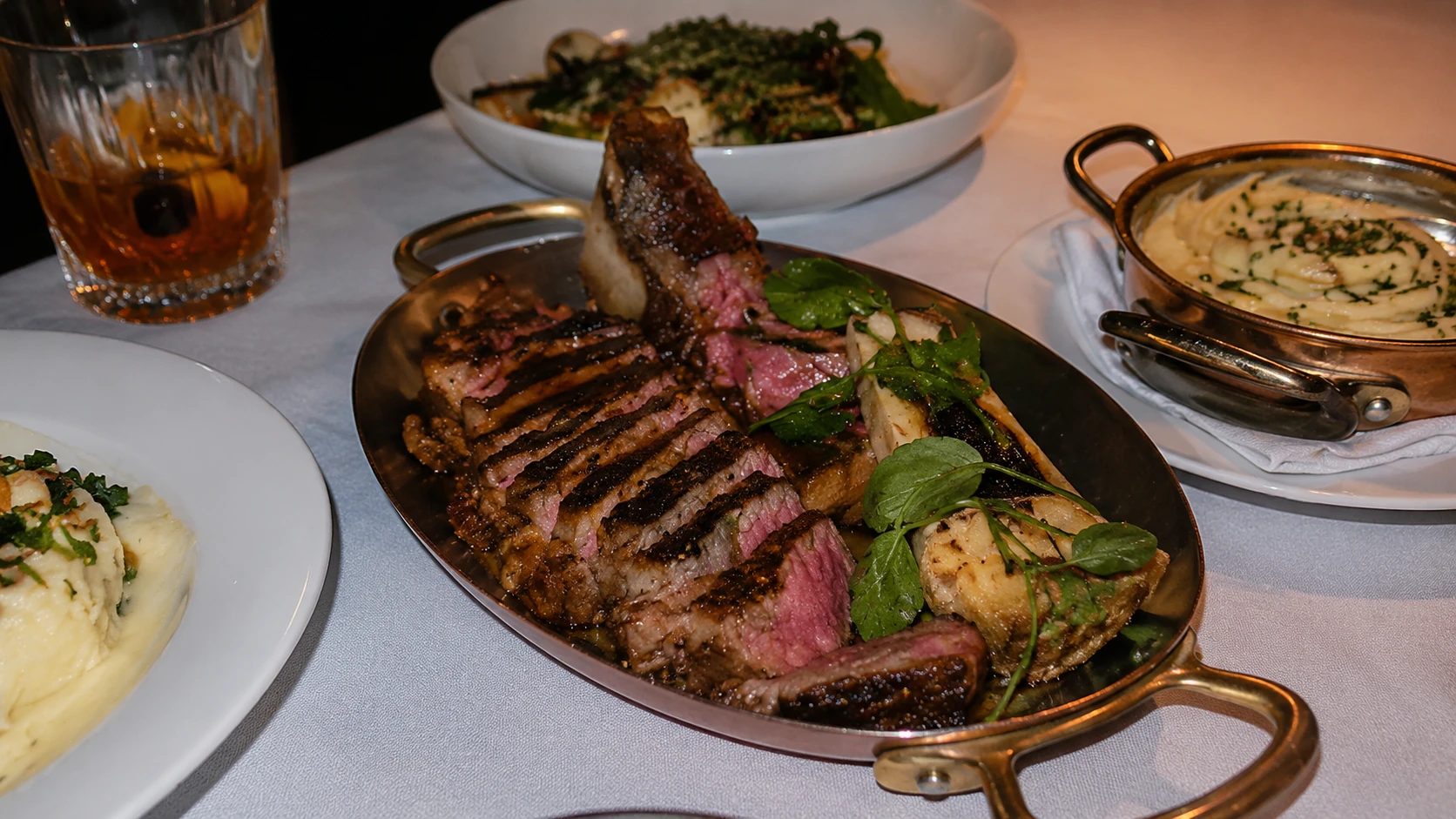 Sliced steak with sides at Maple and Ash steakhouse in Chicago