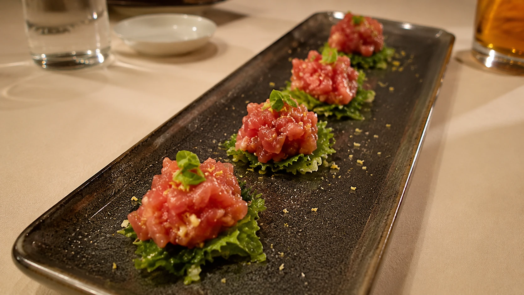 Tuna tartare bites on a black plate at Miru Chicago