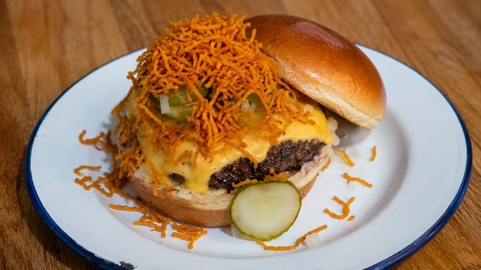 Mott St burger with cheese, pickles, and crispy potatoes in Chicago