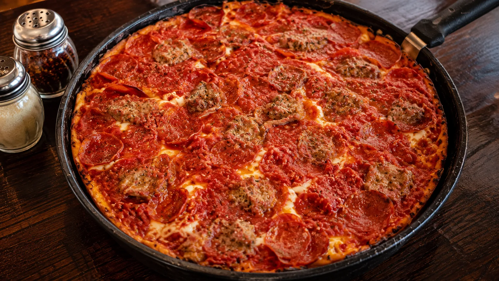 Whole deep dish pan pizza with pepperoni and sausage at Pequod’s Chicago