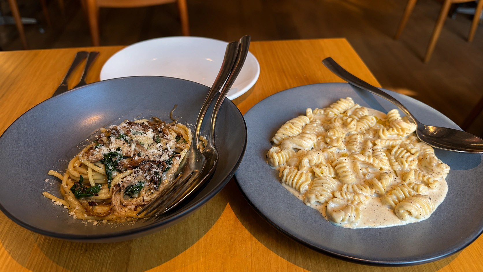 Pasta dishes on a wood table at Rose Mary in Chicago