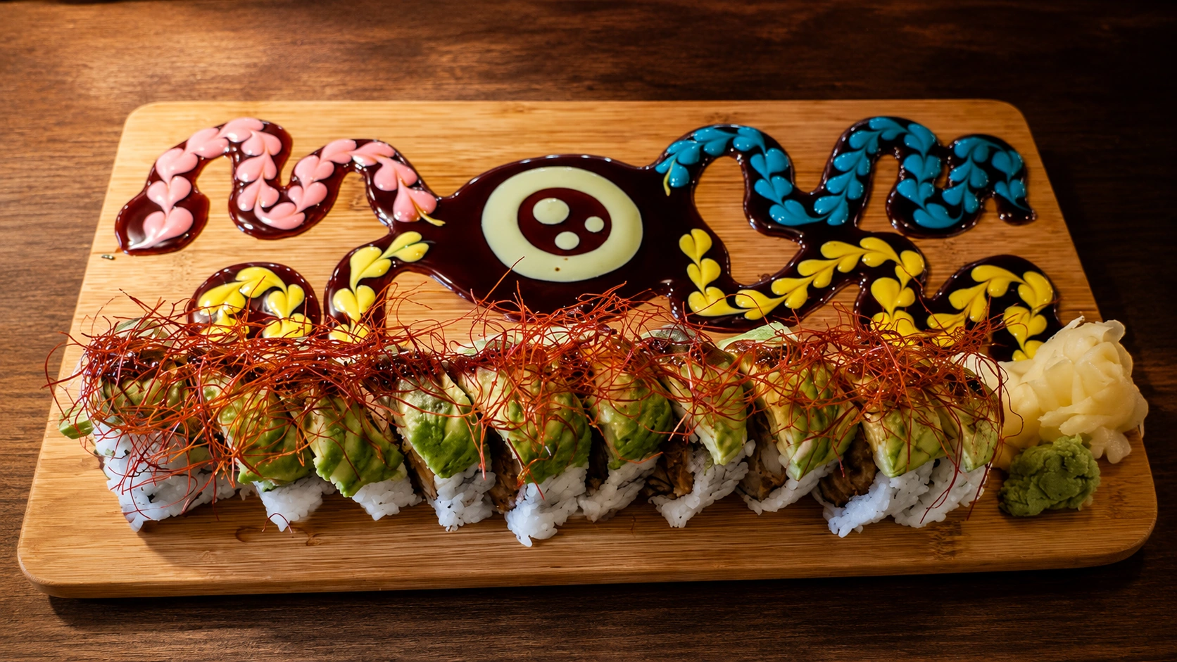 Sushi roll with colorful sauce design at Yuzu in Chicago